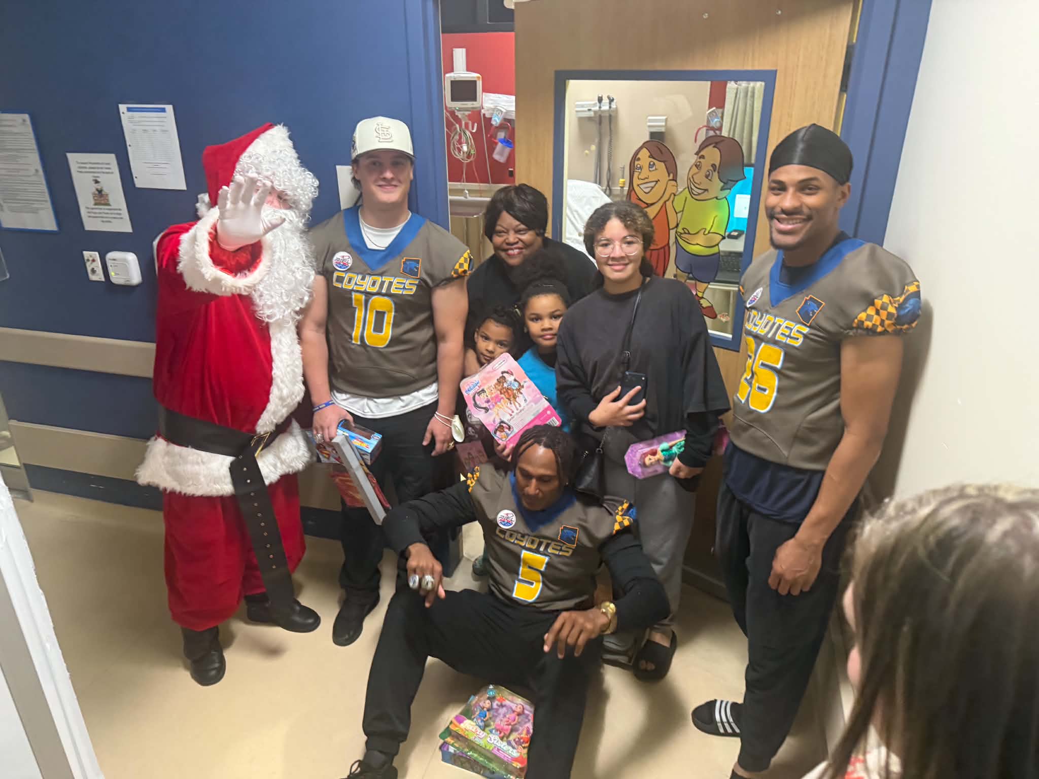 Santa and volunteers visiting families with toys at a hospital